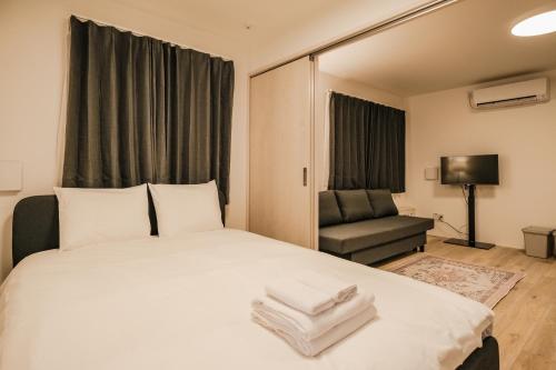 a bedroom with a large white bed and a chair at Apb 两国 in Tokyo