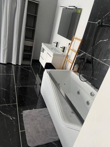 une salle de bain avec une baignoire blanche et un lavabo dans l'établissement Maison de vacances familiale en Provence, à Monteux