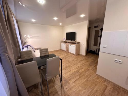 a room with a table and chairs and a television at Hariduse 20 in Sillamäe