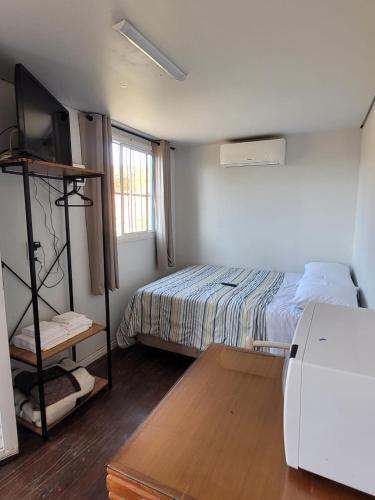 a bedroom with a bed and a television in it at Hospedagem Caminho do Parque in Vacaria