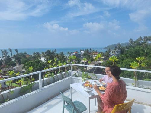 two women sitting at a table on a balcony at X Mirissa in Mirissa