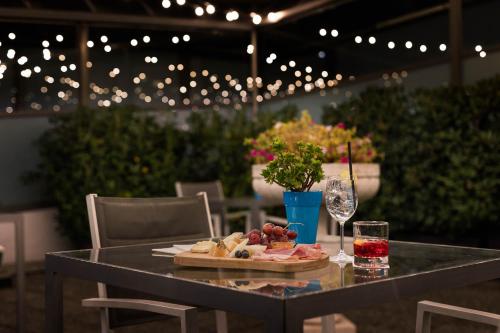 a table with a plate of food and a glass of wine at iH Hotels Milano St. John in Sesto San Giovanni