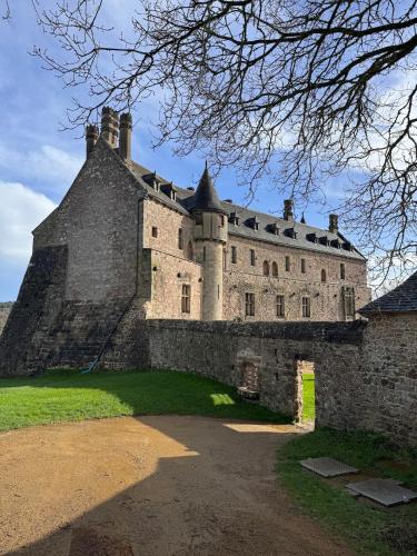 an old castle on a green field with a tree at Le studio in Pontrieux