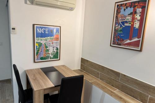 une salle à manger avec une table en bois et des photos murales dans l'établissement Cosy studio near beach and Museum of Fine Arts, à Nice