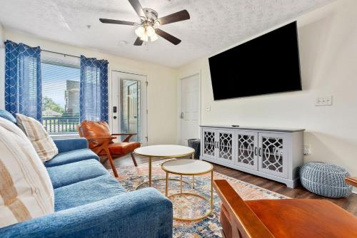 a living room with a blue couch and a flat screen tv at New 4BR 4BA AU Oasis 2 Mins to Downtown & Stadium Sleeps 10 in Auburn