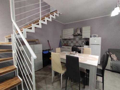 a kitchen and dining room with a table and a staircase at Casa Luisa casa vacanze in Civita Castellana