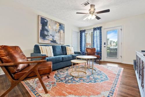 a living room with a blue couch and a table at New 4BR 4BA AU Oasis 2 Mins to Downtown & Stadium Sleeps 10 in Auburn