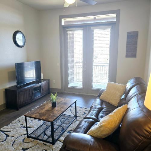 a living room with a leather couch and a coffee table at Convention Center Downtown Escape in Houston