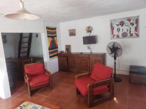 Una sala de estar con dos sillas y un televisor. en Flor de Lis Casa, en La Paloma