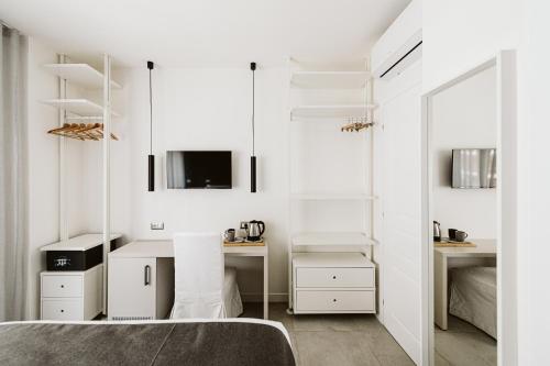 una camera da letto con pareti bianche, un letto e uno specchio di B&B LUMAS a Roma