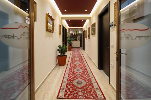 a hallway with a red rug on the floor at Hotel Mimani in Berat
