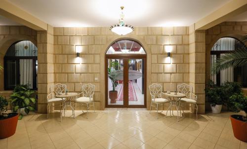 eine Lobby mit Tischen und Stühlen in einem Gebäude in der Unterkunft Hotel Mimani in Berat