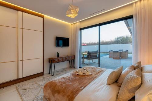 a bedroom with a large bed and a sliding glass door at Villa Eline - Wifi, Piscine chauffée, Sans vis-à-vis in Marrakech