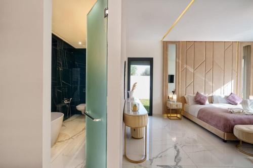 a bedroom with a bed and a bathroom with a tub at Villa Eline - Wifi, Piscine chauffée, Sans vis-à-vis in Marrakech