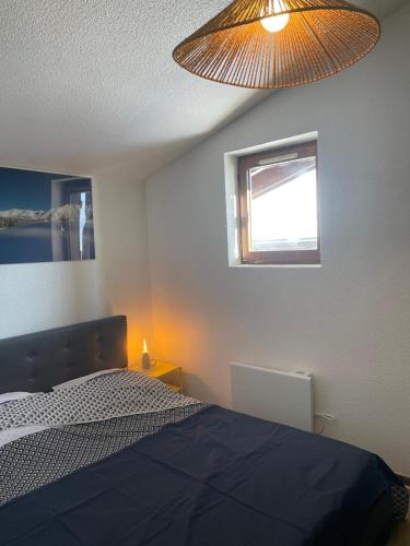 - une chambre avec un lit, une fenêtre et une lampe dans l'établissement Appartement 6 pers proche des pistes, à Praz-sur-Arly