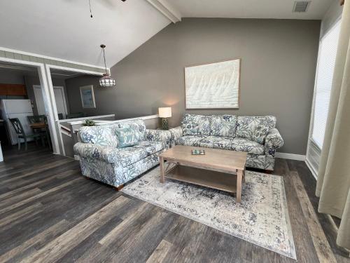 a living room with two couches and a coffee table at Cape Hatteras Motel in Buxton