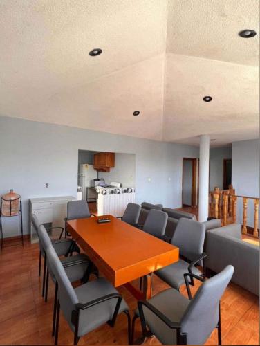 a dining room with a table and chairs and a couch at Habitación doble CAPU in San Felipe Hueyotlipan