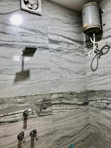 a bathroom with a marble wall with two sinks at HOTEL HOLY CITY in Amritsar