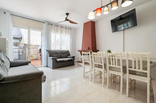 a living room with a table and chairs and a tv at Hauzify I Casa Gala Placidia in Creixell