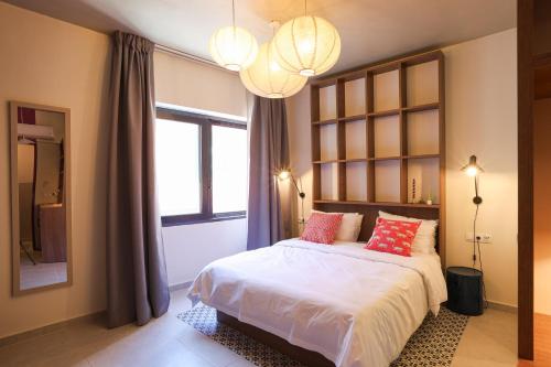 a bedroom with a bed with pink pillows and a window at Dogpound Hotel in Athens