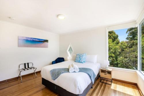 a bedroom with a bed and a large window at Lemonade by the Beach - Serene Huon Valley Retreat with Water Views in Surveyors Bay
