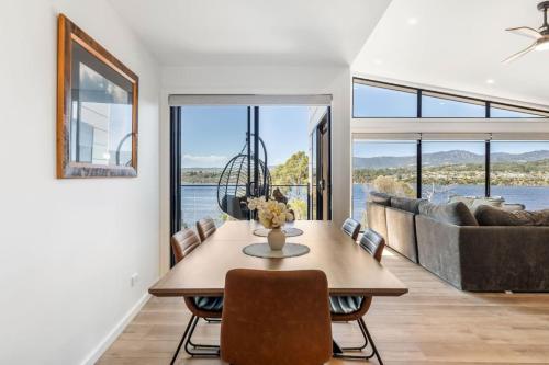 a dining room with a table and a couch at Austins Ferry Haven Modern Waterfront Retreat in Austins Ferry