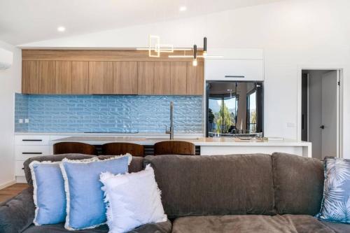 a living room with a couch and a kitchen at Austins Ferry Haven Modern Waterfront Retreat in Austins Ferry