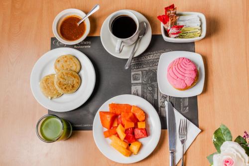 a table with plates of food and a cup of coffee at Paris FC Hotel in Poza Rica de Hidalgo