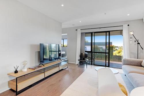 a living room with a couch and a tv at The Base Guest Suite with Wi-Fi and Deck in Auckland