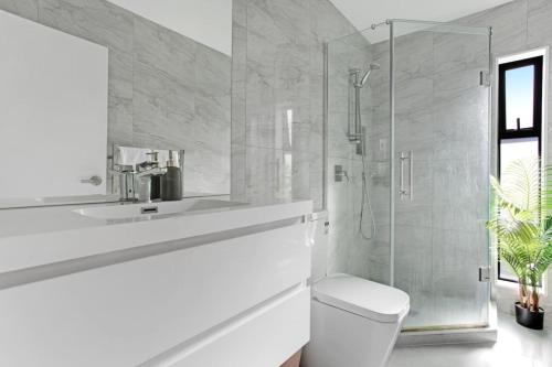 a bathroom with a toilet and a glass shower at The Base Guest Suite with Wi-Fi and Deck in Auckland