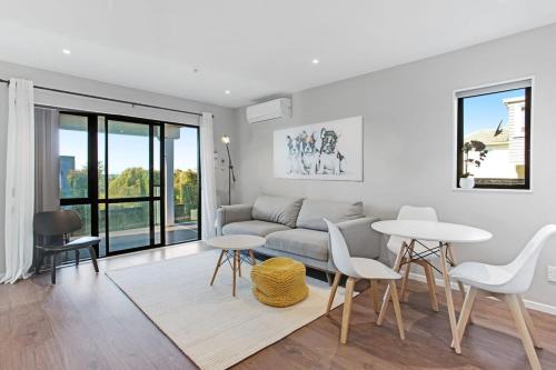 a living room with a couch and a table and chairs at The Base Guest Suite with Wi-Fi and Deck in Auckland