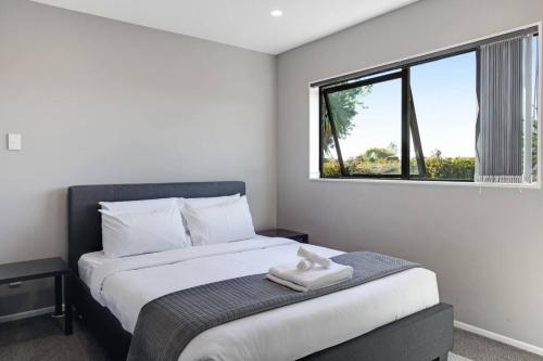 a bedroom with a large bed with a window at The Base Guest Suite with Wi-Fi and Deck in Auckland