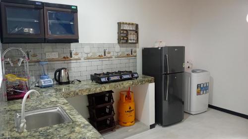 a kitchen with a refrigerator and a sink at Cinnamon garden villa in Weligama