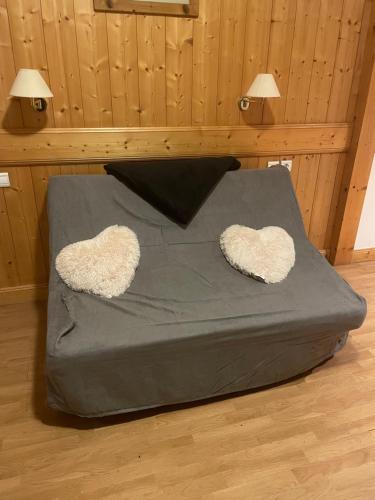 - un lit avec deux oreillers en forme de cœur dans l'établissement Appartement 4 personnes, à Combloux