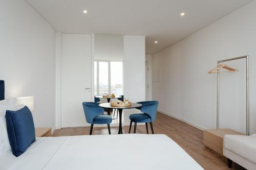 a bedroom with a bed and a table and chairs at Feel Porto Lapa Collection Flats in Porto