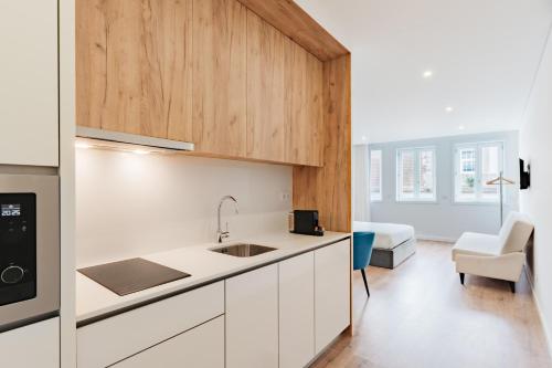 a kitchen with a sink and a couch in a room at Feel Porto Lapa Collection Flats in Porto