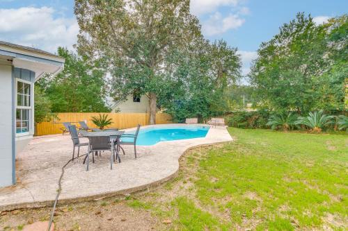 a patio with a table and chairs next to a pool at Foosball Games and Al Fresco Dining Pensacola Home! in Pensacola