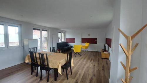 a living room with a table and yellow chairs at Gîte Centre Alsace in Nothalten