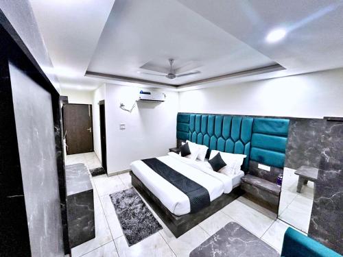 a bedroom with a large bed with a blue headboard at Hotel The Katra Avenue in Katra