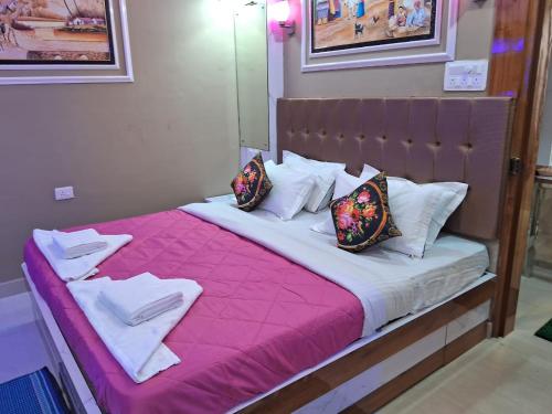 - un grand lit avec des draps et des oreillers roses dans l'établissement Sagar Royale, à Purî