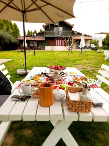 un tavolo da picnic bianco con del cibo sopra di La Casa Verde Butik Otel a Smirne