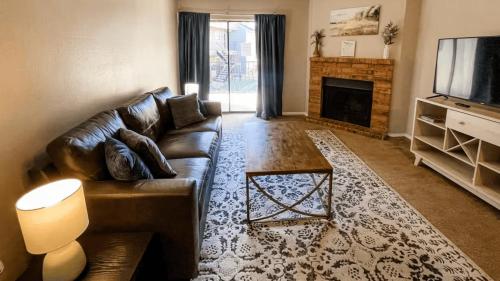 a living room with a leather couch and a fireplace at 10 Min to Downtown - Pet-friendly, TV with Parking in Robstown