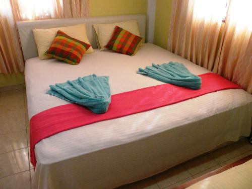 a bed with two mitts on top of it at Henderson Airport Residence in Negombo