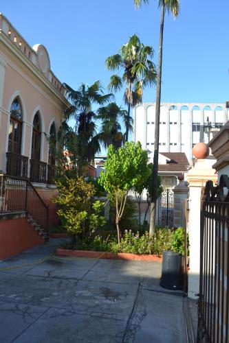 a building with a gate and palm trees in a yard at Pousada Estação do Trem in São João del Rei