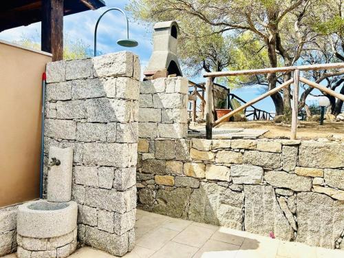 a stone wall in front of a building at Villa Acquamarina a 2 passi dal mare in Simius