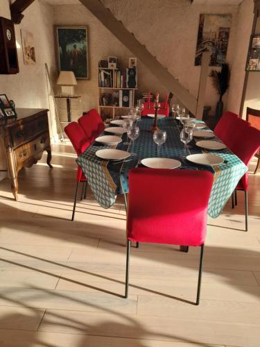 une salle à manger avec une table et des chaises rouges dans l'établissement Maison de la Truffière, à Bertric-Burée