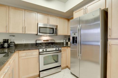 a kitchen with wooden cabinets and a stainless steel refrigerator at Beautiful 1 Bedroom Apartment at Pentagon City in Arlington