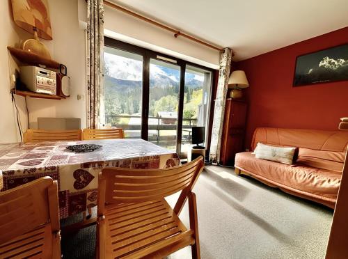 un salon avec une table, des chaises et un canapé dans l'établissement Le Saphir - Vue spectaculaire sur les Montagnes, à Saint-Gervais-les-Bains