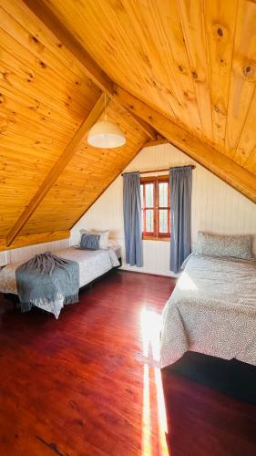 two beds in a room with a wooden ceiling at Vista Encantada Complejo in Villa Carlos Paz