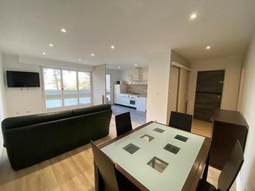 un soggiorno con un divano e un tavolo di Apartement entier - 8 personnes - Angoulême ad Angoulême
